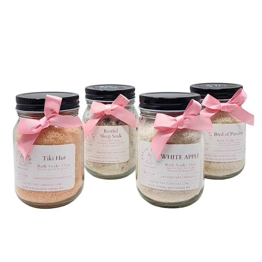 Four jars of bath salts with pink bows on a white background